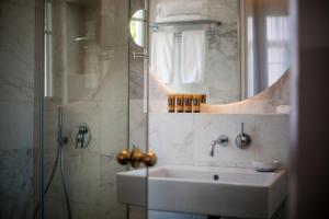 a bathroom with a sink and a shower and a mirror at Hotel Nordoy By 7Minds in Tel Aviv
