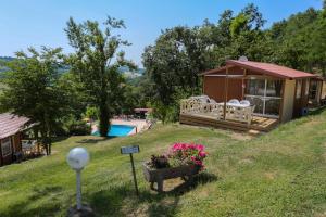 a tiny house with a porch and a pool at Camping Le Bourdieu in Durfort