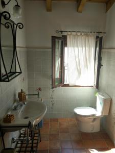 a bathroom with a white toilet and a sink at Casa Rural La Torre in Almonaster la Real