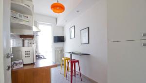 a kitchen with two stools and a table in a room at Italianway-Alzaia Naviglio Pavese in Milan