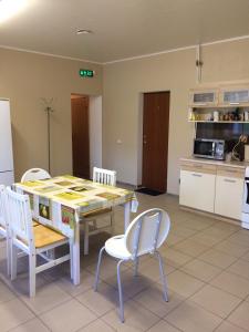 een keuken en eetkamer met een tafel en stoelen bij Westwind puhkemaja in Kunda