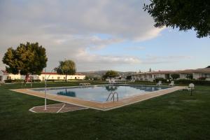 a swimming pool in a yard with trees and buildings at Hotel Apartamento Do Golfe in Vilamoura