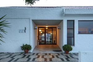 a door to a building with two potted plants at Hotel Apartamento Do Golfe in Vilamoura