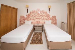 two twin beds in a room with a headboard at Hotel Apartamento Do Golfe in Vilamoura