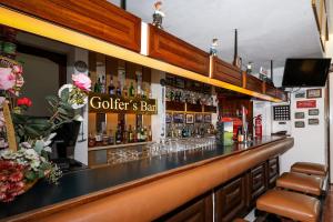 a bar with a counter and a shelf of alcohol at Hotel Apartamento Do Golfe in Vilamoura
