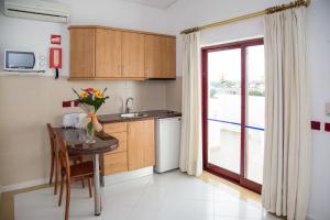 a small kitchen with a table and a window at Hotel Apartamento Do Golfe in Vilamoura