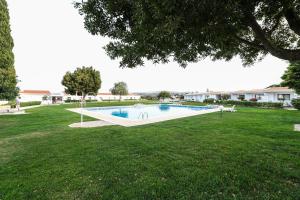 a large swimming pool in a grassy yard at Hotel Apartamento Do Golfe in Vilamoura