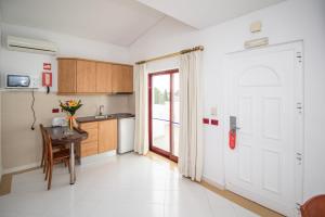 a kitchen with a table and a white door at Hotel Apartamento Do Golfe in Vilamoura