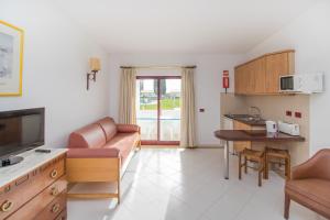 a living room with a couch and a table at Hotel Apartamento Do Golfe in Vilamoura