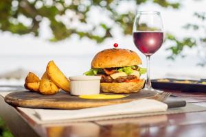 a sandwich and fries on a table with a glass of wine at Samed Villa Resort in Ko Samed