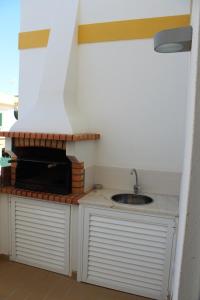 uma cozinha com um lavatório e uma bancada em Vila Gaio na Manta Rota