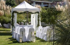 a white table topped with white chairs and umbrellas at Rhodes Bay Hotel & Spa in Ixia