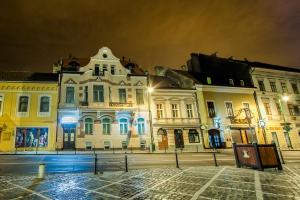 a group of buildings on a street at night at Residence Central Annapolis in Braşov