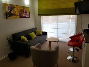 sala de estar con sofá y taburete rojo en Perla del Elqui Pacifico, en La Serena