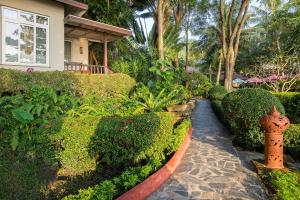 a garden with a fire hydrant in front of a house at Samed Villa Resort in Ko Samed