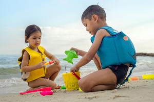 a boy and a girl playing in the sand on the beach at Samed Villa Resort in Ko Samed