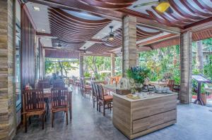 a restaurant with tables and chairs and people sitting at them at Samed Villa Resort in Ko Samed