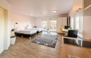 ein Wohnzimmer mit einem Bett und einem Schreibtisch in einem Zimmer in der Unterkunft Hotel Flensburg Akademie in Flensburg