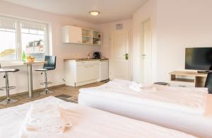 ein weißes Schlafzimmer mit einem Bett und einer Küche in der Unterkunft Hotel Flensburg Akademie in Flensburg