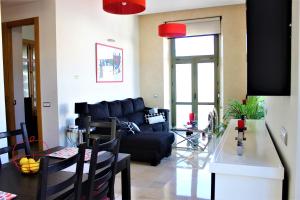 a living room with a black couch and a table at Luxury Apartment Sierpes in Seville