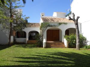 a white house with a gate and a yard at L´Escala in Denia