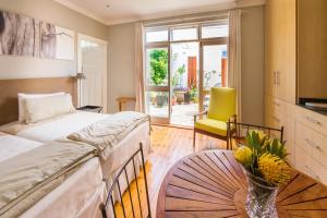 a bedroom with two beds and a table with a vase of flowers at B's Place in Port Elizabeth