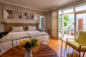 Un dormitorio con una cama y una mesa con flores. en B's Place en Puerto Elizabeth