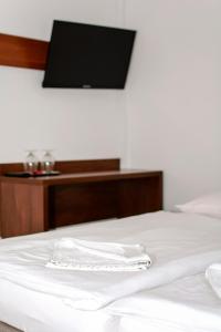 a bed with a white towel on top of it at Noclegi Europa in Bolesławiec