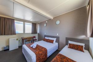 Un pat sau paturi într-o cameră la The Australian Hotel Murgon