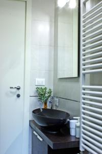baño con lavabo negro y espejo en Relax Suite Nazario, en Bolonia