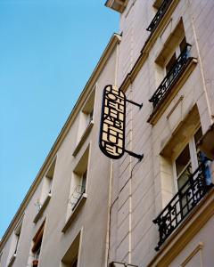 a clock on the side of a building at Hotel Habituel in Paris