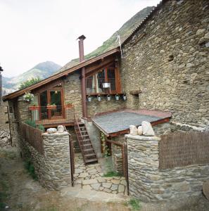 IsavarreにあるLa Llúpiaの前に階段のある古い石造りの家