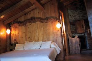 um quarto com uma cama grande e uma parede de madeira em La Llúpia em Isavarre