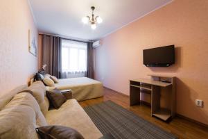 ヤロスラヴリにあるApartments Romanovskyのソファ、ベッド、テレビが備わるホテルルームです。