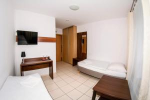 a hotel room with two beds and a television at Motel w Łące in Bolesławiec