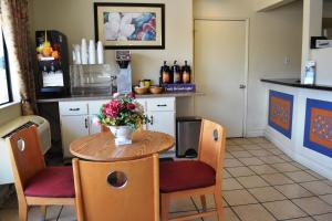 una cocina con una mesa con un jarrón de flores. en Vagabond Inn Fresno, en Fresno