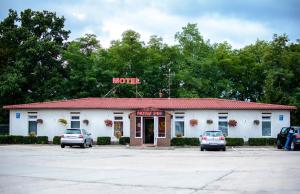 a motel with two cars parked in a parking lot at Motel w Łące in Bolesławiec