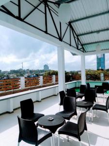 a patio with tables and chairs on a roof at Queens Park Apartments in Colombo