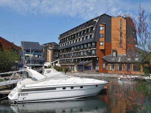a white boat sitting in the water next to a building at Les marinas vue Mer in Deauville +10 photos