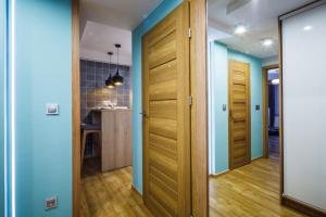 un couloir avec des murs bleus et des portes en bois dans l'établissement Apartament Makuszynsky, à Zakopane