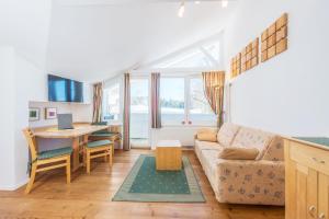 a living room with a couch and a table at Landhaus & Ferienwohnungen Bergrast in Ramsau am Dachstein