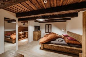 a bedroom with two beds and a wooden ceiling at Penzion Víno Hruška Pardubice in Pardubice