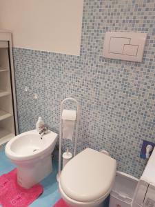 ein Badezimmer mit einem weißen WC und einem Waschbecken in der Unterkunft Casa Gentile in Syrakus