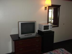 einen TV und eine Mikrowelle auf der Kommode im Zimmer in der Unterkunft Sunrise Inn in Everett