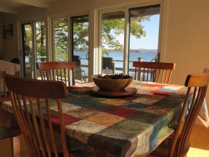 a dining room table with a view of the water at Acadia Ocean Front Garden Cottages in Trenton