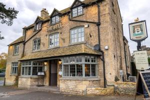 an old building in the middle of the street at The Bell & Stuart House in Stow on the Wold