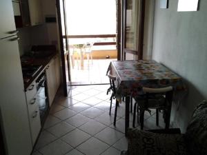 cocina con mesa, mesa y sillas en Appartamento 89, en Torre dei Corsari