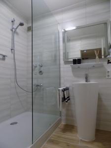a bathroom with a shower and a sink and a mirror at Bergschlössl Fewo 28 in Oberaudorf