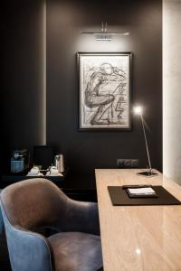 an office with a desk with a chair and a drawing on the wall at Hotel Platinia in Cluj-Napoca