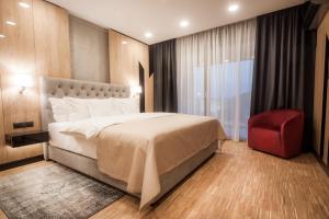 
a bedroom with a large bed and a large window at Hotel Platinia in Cluj-Napoca
